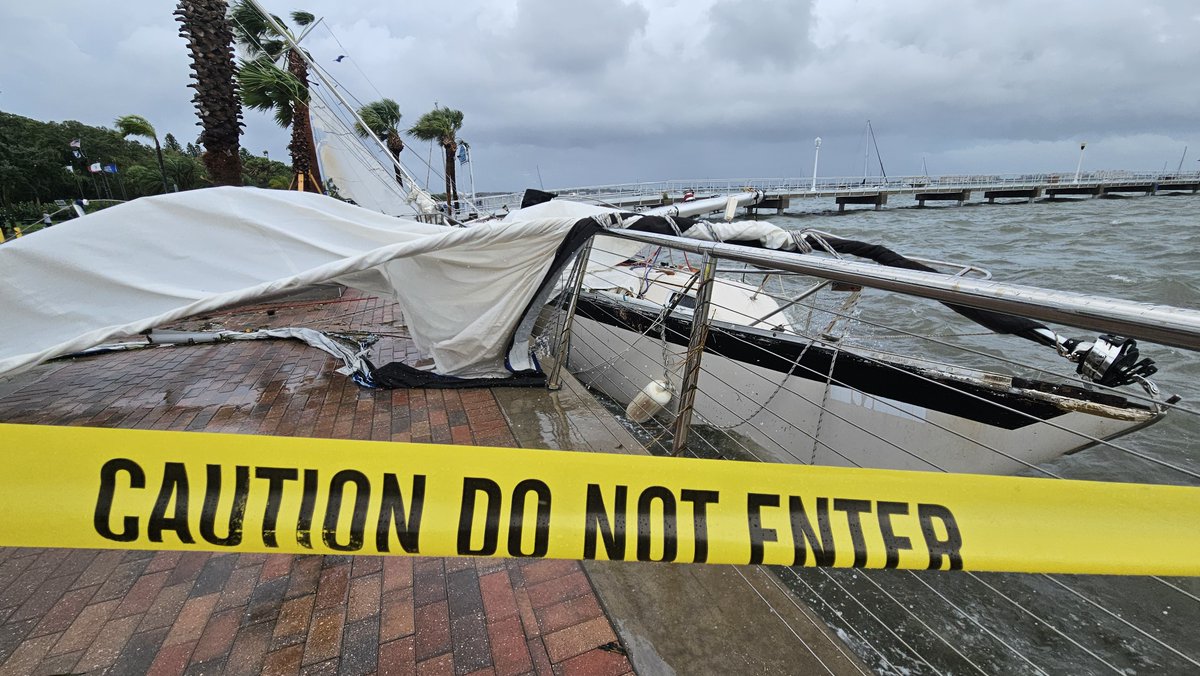 Scene of a boat knocked partially on its side and some considerable street flooding after Hurricane Debby lashed Gulfport