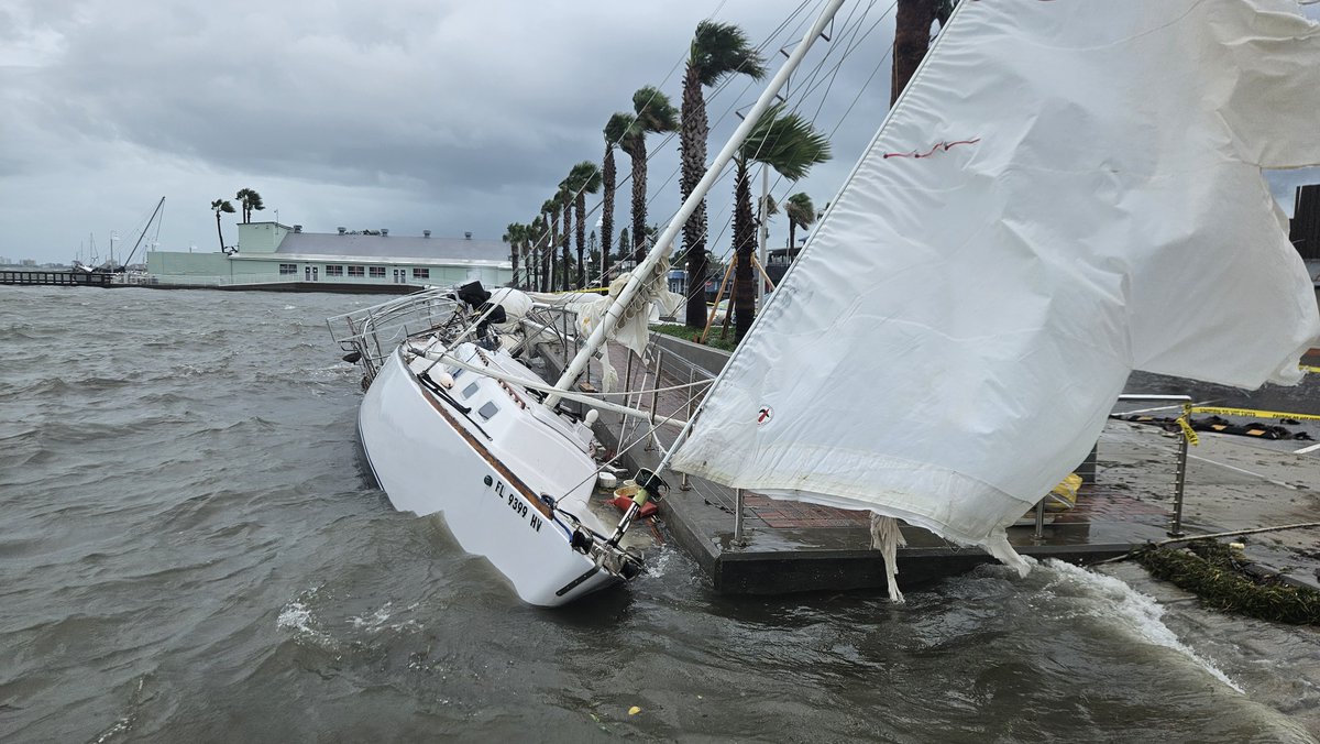 Scene of a boat knocked partially on its side and some considerable street flooding after Hurricane Debby lashed Gulfport